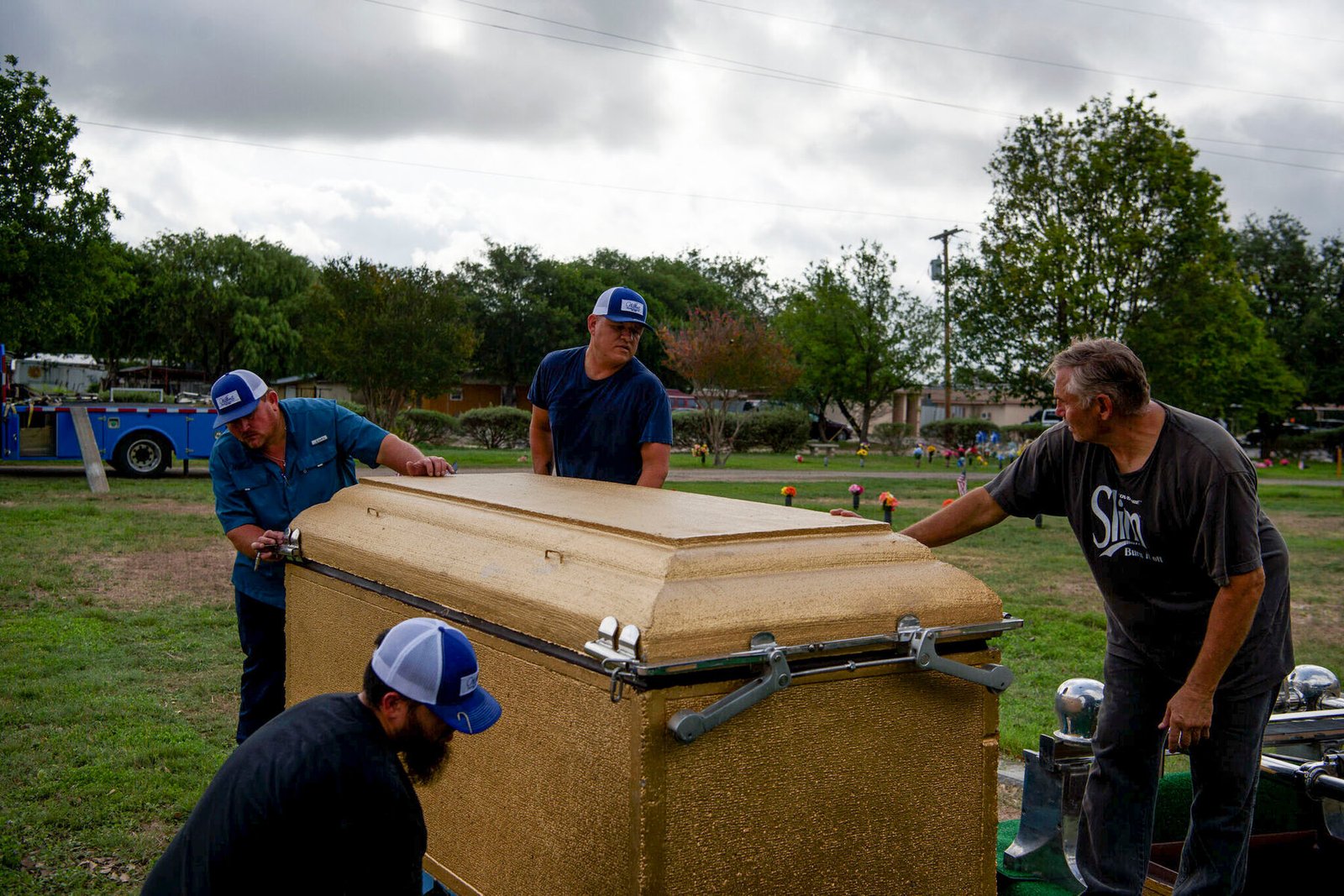 Funeral home employees maneuvered the vaults for the burial of Irma Garcia, who was killed during the shooting, and her husband, Joe Garcia, who died of a heart attack two days later.